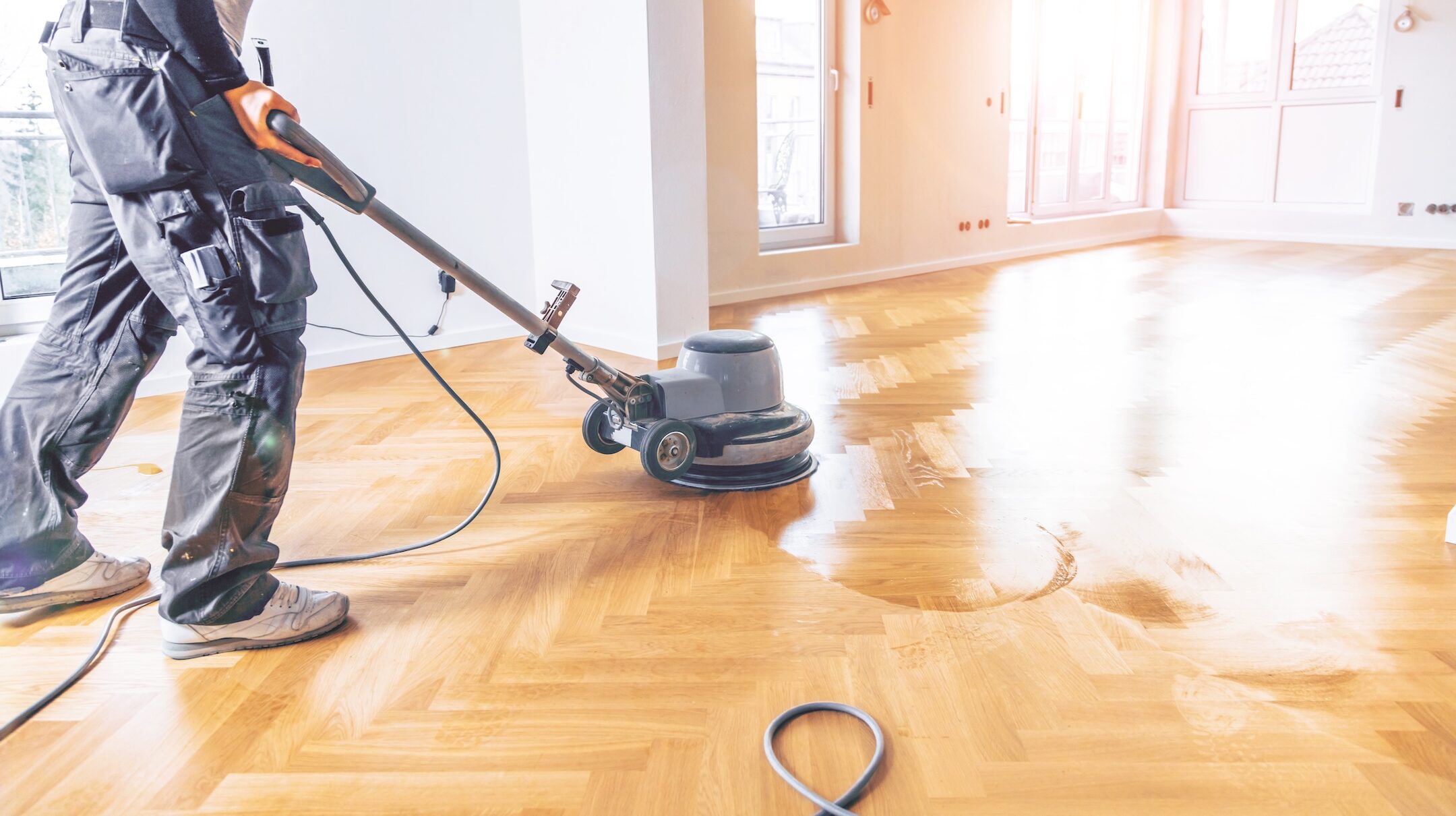 Varnishing of oak parquet floor, workers hand and tool